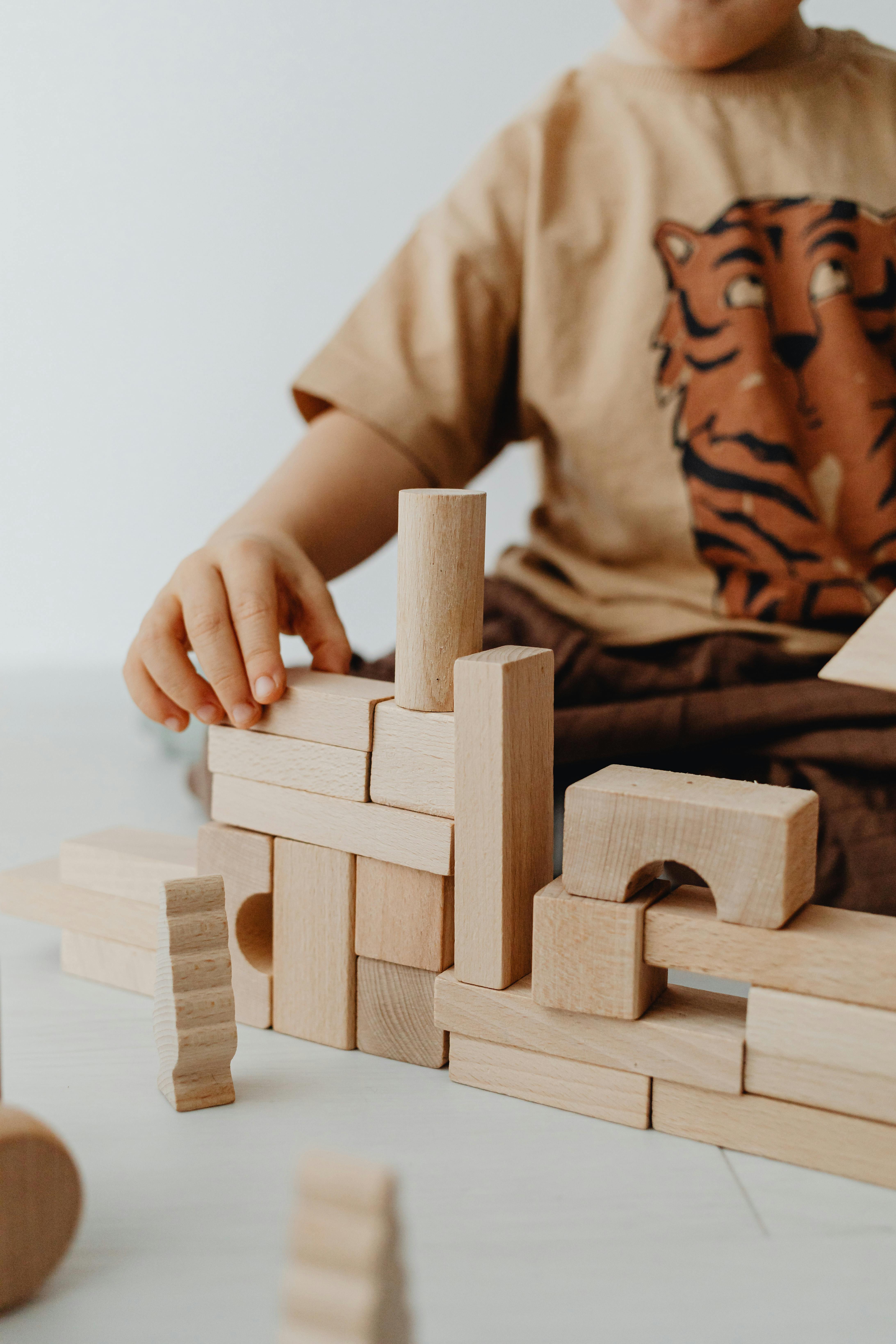 Selective Focus Photo of a Kid Stacking Building Blocks