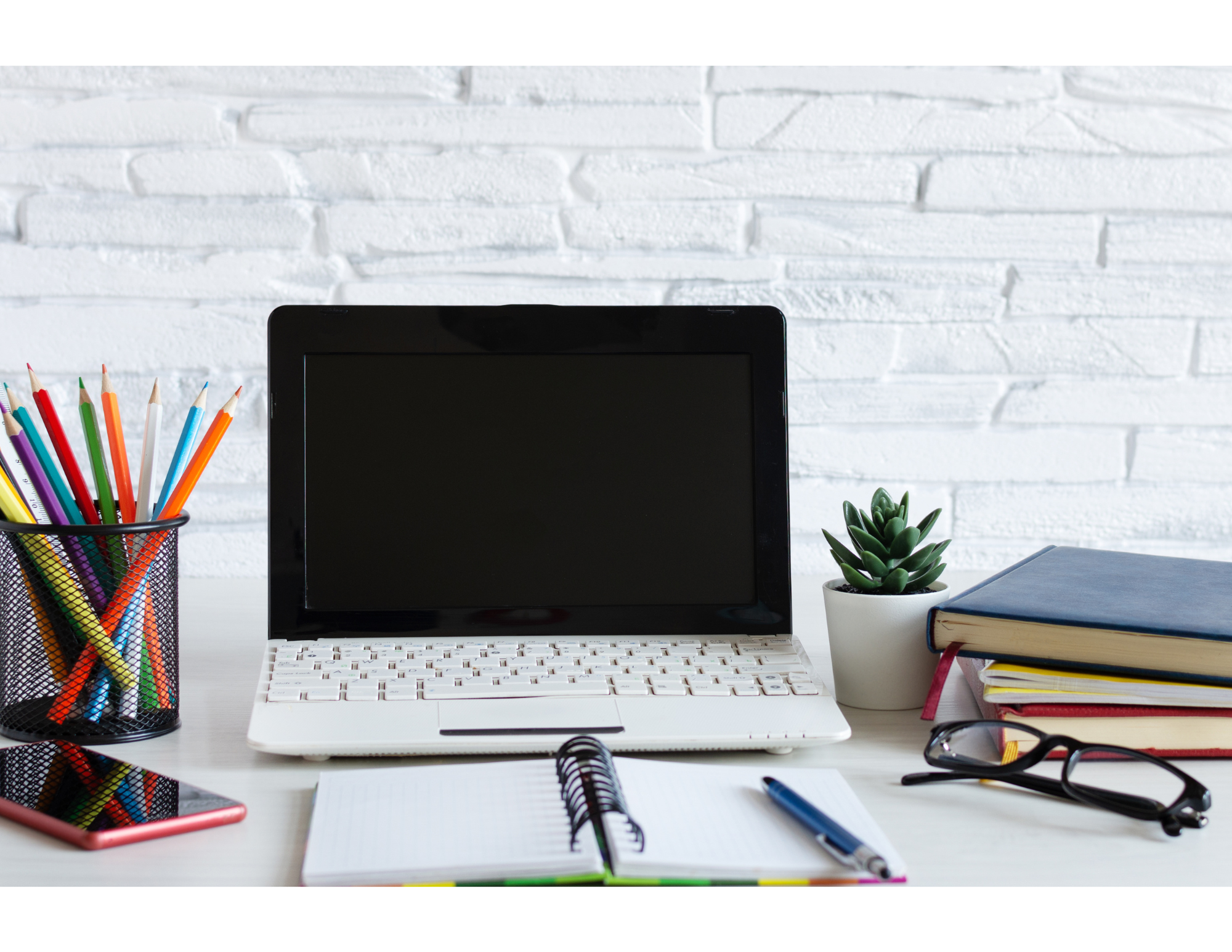 Desk with pencils, laptop, books and notebook